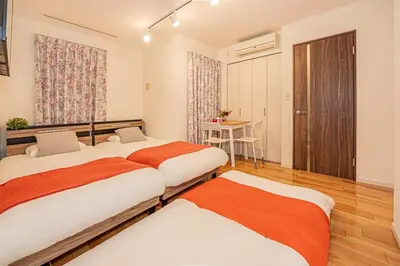 a bedroom with two beds and a table in it at Skytree Stay Home, a 4-minute walk from Oshiage Station, a private house with an elevator in Tokyo