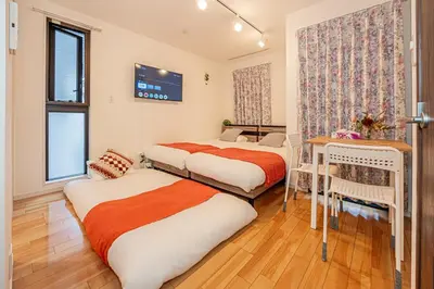 a bedroom with two beds and a desk in it at Skytree Stay Home, a 4-minute walk from Oshiage Station, a private house with an elevator in Tokyo