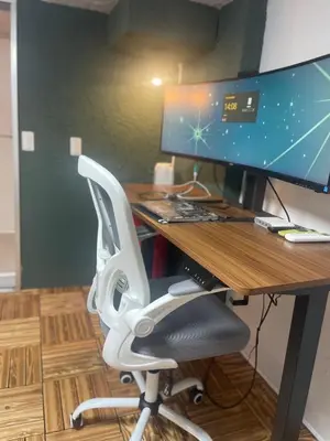 a desk with a computer monitor and a chair at Aila apartment in Tokyo