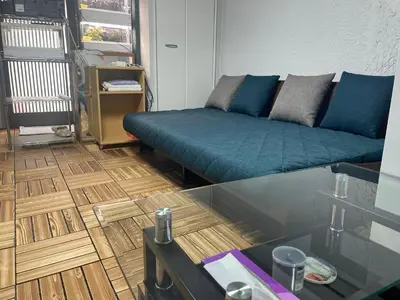 a living room with a couch and a glass table at Aila apartment in Tokyo