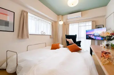 a bedroom with a white bed and a tv at Felizstay 907 in Tokyo