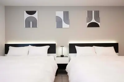 two beds sitting next to each other in a bedroom at Ruhe Ikebukuro in Tokyo