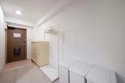 a room with two white benches in front of a door at Ruhe Ikebukuro in Tokyo