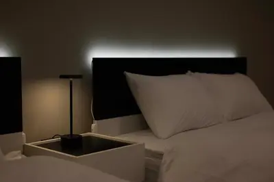 a bed with a black headboard and a white pillow at Ruhe Ikebukuro in Tokyo