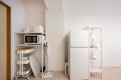 a kitchen with a white refrigerator and a microwave at Ruhe Ikebukuro in Tokyo