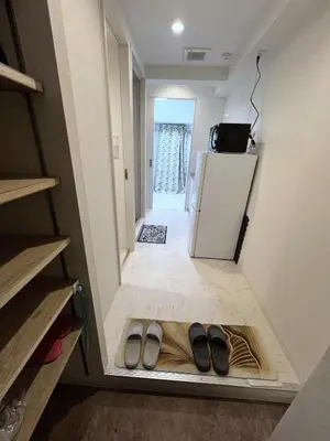 a pair of shoes in the middle of a room with a refrigerator at \u6d45\u8349\u5bfa\u6c11\u6cca in Tokyo
