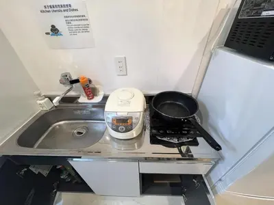 a small kitchen with a stove and a sink at \u6d45\u8349\u5bfa\u6c11\u6cca in Tokyo