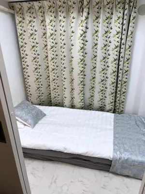 a small bed in a room with a curtain at \u6d45\u8349\u5bfa\u6c11\u6cca in Tokyo