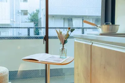 a vase of flowers on a table in a kitchen at ISSHUKU Noma \u5317\u65b0\u5bbfI -201 Triple Room in Tokyo