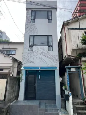 a building with a blue door in front of it at \u5343\u675f3\u4e01\u76ee in Tokyo