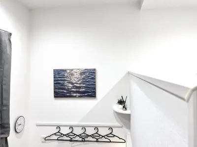 a white staircase with a painting on the wall at 新宿Shin-Ōkubo Aeroland 2 in Tokyo