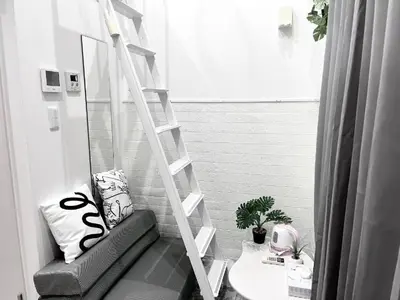 a ladder in a room with a couch and a table at 新宿Shin-Ōkubo Aeroland 2 in Tokyo