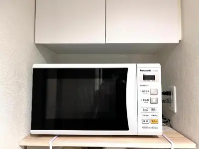 a microwave oven sitting on a shelf in a kitchen at 新宿Shin-Ōkubo Aeroland 2 in Tokyo