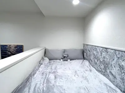 a stuffed teddy bear sitting on a bed in a room at 新宿Shin-Ōkubo Aeroland 2 in Tokyo