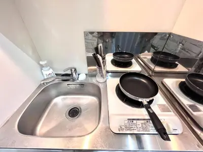 a kitchen sink with a frying pan on a stove at 新宿Shin-Ōkubo Aeroland 2 in Tokyo