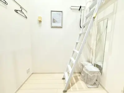 a ladder in a white room with a mirror at 新宿Shin-Ōkubo Aaanun 6 in Tokyo