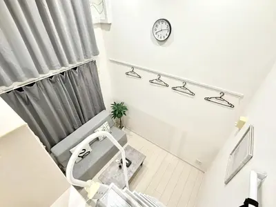a hospital room with a chair and a clock on the wall at 新宿Shin-Ōkubo Aaanun 6 in Tokyo