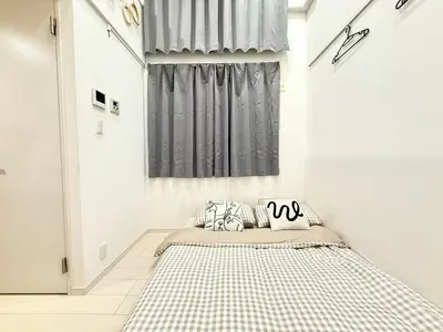 a bedroom with a bed with a checkered rug at 新宿Shin-Ōkubo Aaanun 6 in Tokyo