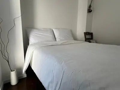 a bedroom with a bed with white sheets at HigashiNakano 3 rooms 1 bath with 2 different view in Tokyo