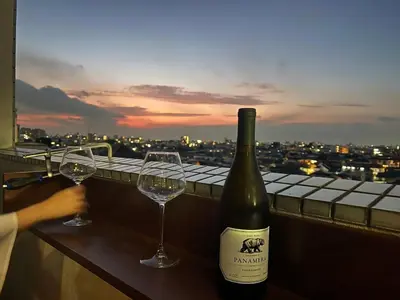 a bottle of wine and two wine glasses on a ledge at HigashiNakano 3 rooms 1 bath with 2 different view in Tokyo