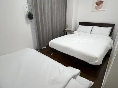 two beds in a small room with white sheets at HigashiNakano 3 rooms 1 bath with 2 different view in Tokyo