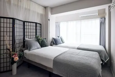 two beds in a bedroom with a window at Tokyo Tower Roppongi walk 4 bed, Direct bus to Shibuya in Tokyo