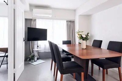 a dining room with a wooden table and chairs at Tokyo Tower Roppongi walk 4 bed, Direct bus to Shibuya in Tokyo