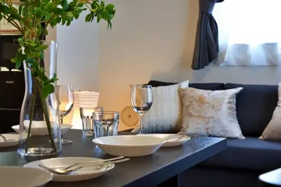 a table with plates and wine glasses on a couch at Chill Place 125 Kameari in Tokyo