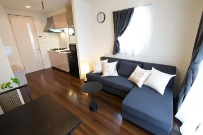 a living room with a blue couch and a table at Chill Place 125 Kameari in Tokyo