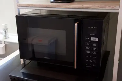 a microwave oven sitting on top of a shelf at Chill Place 125 Kameari in Tokyo