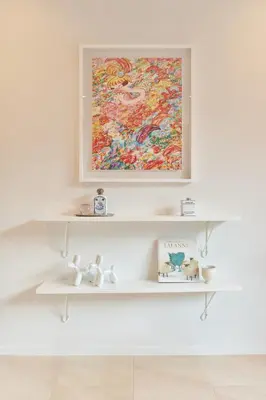 a white shelf with a painting on the wall at Mint House Ebisu - 3 Story, Artsy & Modern Home in Shibuya in Tokyo