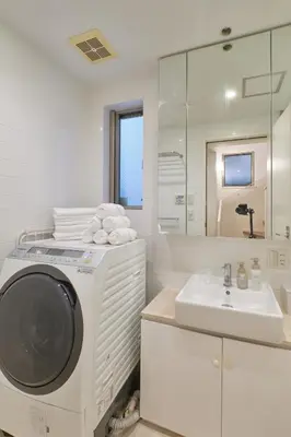 a white bathroom with a washing machine and a sink at Mint House Ebisu - 3 Story, Artsy & Modern Home in Shibuya in Tokyo
