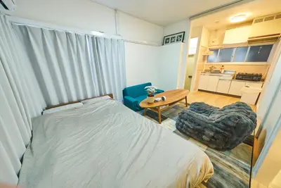 a bedroom with a bed and a chair and a table at 11 Under the Moon Shin-Okubo Station 3 minute walk in Tokyo