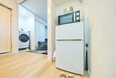a white refrigerator with a microwave on top of it at 11 Under the Moon Shin-Okubo Station 3 minute walk in Tokyo