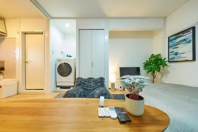 a room with a bed and a table with remote controls at 11 Under the Moon Shin-Okubo Station 3 minute walk in Tokyo