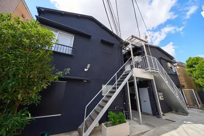 a black building with a staircase next to it at 11 Under the Moon Shin-Okubo Station 3 minute walk in Tokyo