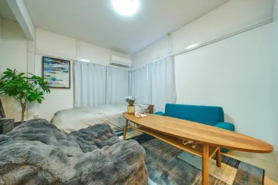 a bedroom with a table and a bed and a blue chair at 11 Under the Moon Shin-Okubo Station 3 minute walk in Tokyo