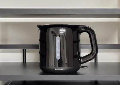 a black tea kettle sitting on a shelf at Blue Sky 3F in Tokyo