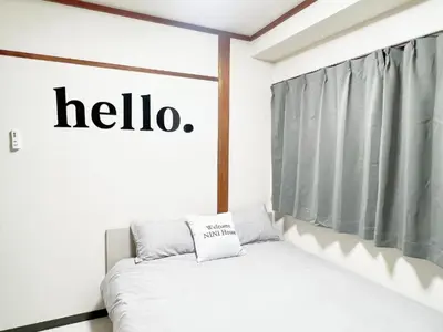 a bed in a room with a hello sign on the wall at \u6c60\u888b\u99c5\u96fb\u8eca4\u5206 2LDK a2 in Tokyo