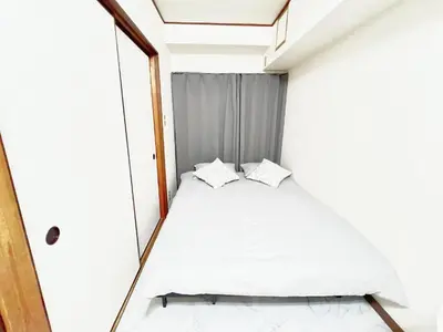 a small bed in a small room with a mirror at \u6c60\u888b\u99c5\u96fb\u8eca4\u5206 2LDK a2 in Tokyo