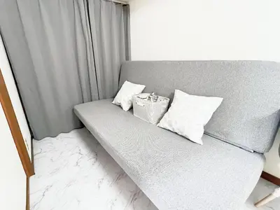 a gray couch with two pillows and a box on it at \u6c60\u888b\u99c5\u96fb\u8eca4\u5206 2LDK a2 in Tokyo
