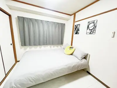 a small bedroom with a bed with a yellow headboard at \u6c60\u888b\u99c5\u96fb\u8eca4\u5206 2LDK a2 in Tokyo