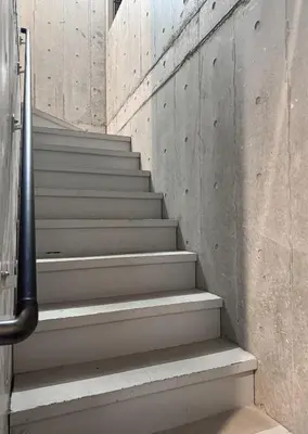 a staircase in a building with a concrete wall at Cozy 1BR Apt in Asakusa-8 min walk Naka Okachimachi station in Tokyo