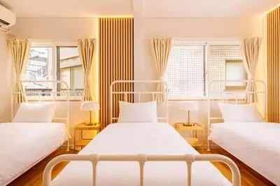 two beds in a room with two windows at Shinjuku Large Entire 3Story House for 9 Near 2 Stations in Tokyo