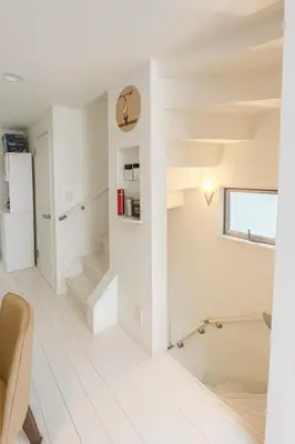 a white kitchen with stairs and a refrigerator at MIKI HOUSE Families and groups welcome \u65b0\u5c0f\u5ca9 private in Tokyo