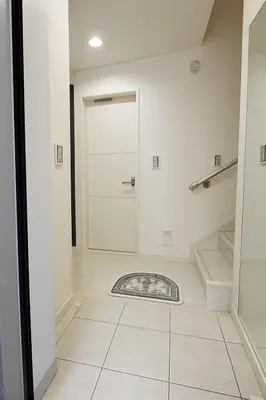 a hallway with a door with a rug on the floor at MIKI HOUSE Families and groups welcome \u65b0\u5c0f\u5ca9 private in Tokyo