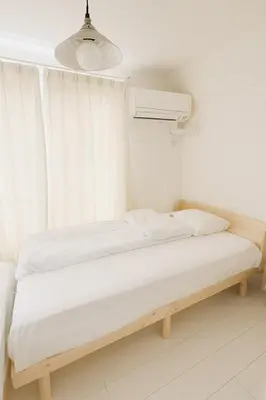 a bed in a room with a window at MIKI HOUSE Families and groups welcome \u65b0\u5c0f\u5ca9 private in Tokyo