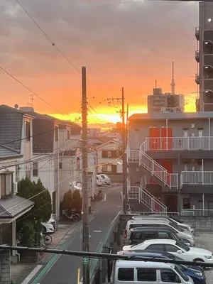 a city street with cars parked in a parking lot at sunset at MIKI HOUSE Families and groups welcome \u65b0\u5c0f\u5ca9 private in Tokyo