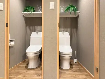 a bathroom with a toilet and two plants on a shelf at Shinjuku Station kabukicho 2minutes big House in Tokyo