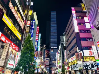 a busy city street at night with a christmas tree at Shinjuku Station kabukicho 2minutes big House in Tokyo